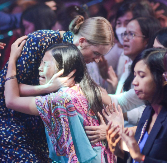 Tamryn embracing a woman during ministry